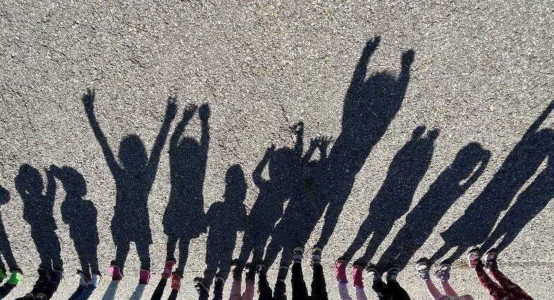 Bild von einem Schatten, von einigen Kindern die nebeneinander stehen.