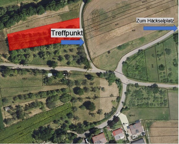 Eine Luftaufnahme zeigt Felder und Wege, mit einem roten Bereich als "Treffpunkt" und einem Pfeil in Richtung "Zum Häckselplatz".